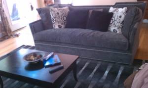 Dark gray couch and black rug.