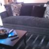Dark gray couch and black rug.