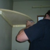 Man putting in Corner Shelves