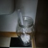Toilet brush in glass vase.