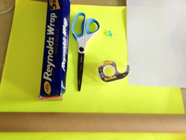 Cardboard tube, aluminum foil, scissors, tape, push pin, and paper.