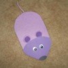 A purple foam mouse shaped mouse pad.