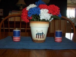 Flag decorated flower pot with red, white, and blue flowers.