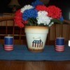 Flag decorated flower pot with red, white, and blue flowers.