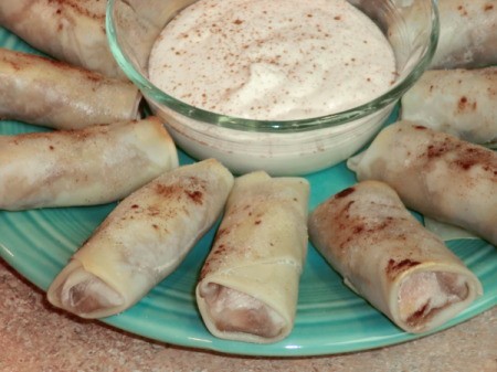 Close up of plate with egg rolls and whipped cream.