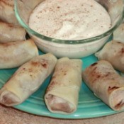 Close up of plate with egg rolls and whipped cream.