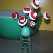Red and white button flowers in salt shaker.