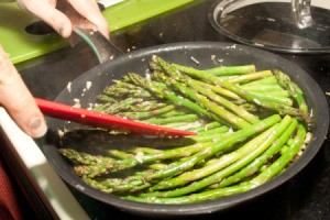 Lemon Ginger Asparagus being sauteed in a pan.
