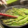 Lemon Ginger Asparagus being sauteed in a pan.