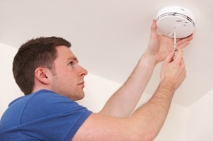 Man Servicing Smoke Alarm