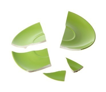 A broken green dish in several pieces