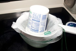 Straining yogurt through a mesh bag and strainer.