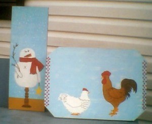 Painted boards with snowman and chickens.