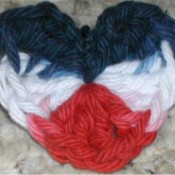 Crochet red, white, and blue heart shaped pin.