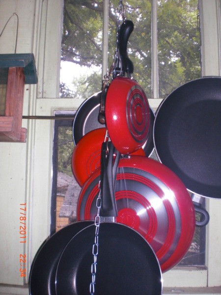 Pots hanging from a chain in the kitchen.