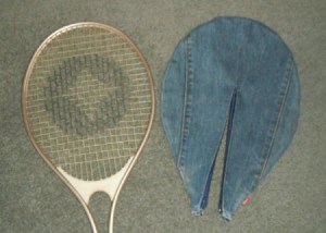 Racket cover next to tennis racket.
