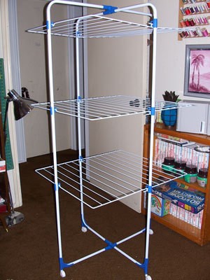 A laundry drying rack in a spare bedroom