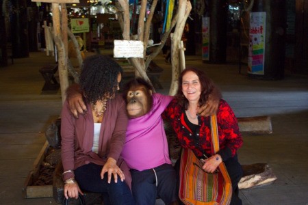 Two women on a bench with the orangutan.