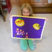 Designer kneeling and displaying finished rug.