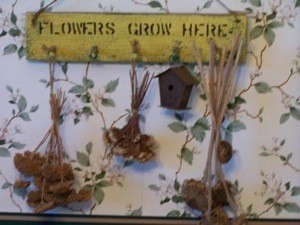 Finished project with dried flowers hanging from pegs.