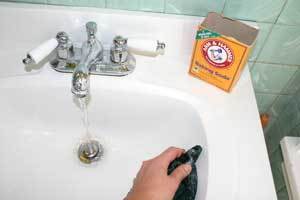 Cleaning sink with baking soda.