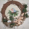 Wreath with cross stitch mounted in center.