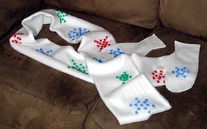 White fleece scarf with red, blue, and green beaded snowflakes.