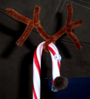 Candy cane decorated with pipe cleaner, google eyes, and a pom pom.
