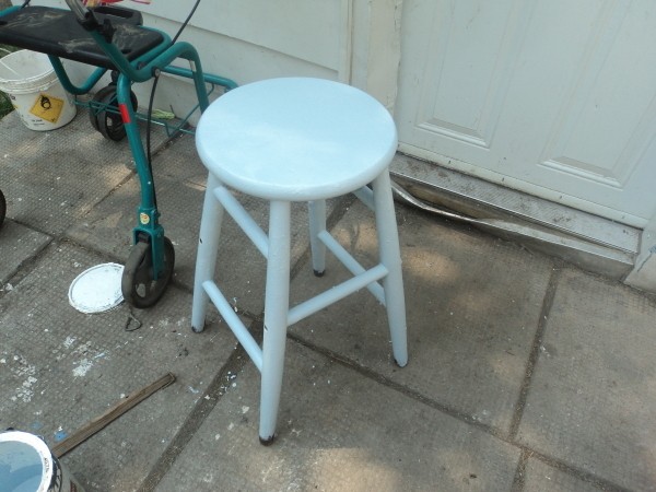 A wooden stool painted blue.