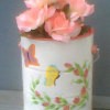 White paint can with spray of pink flowers and butterflies.