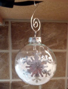 Snow filled glass ornaments with snowflake stickers.
