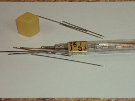 Pencil lead tube with a variety of sewing needles.