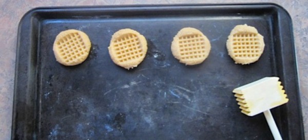 Cookies on baking sheet and tenderizer.