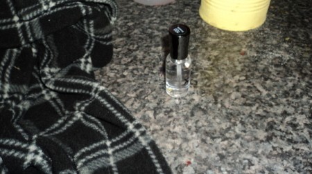 Piece of clothing and bottle of clear nail polish.