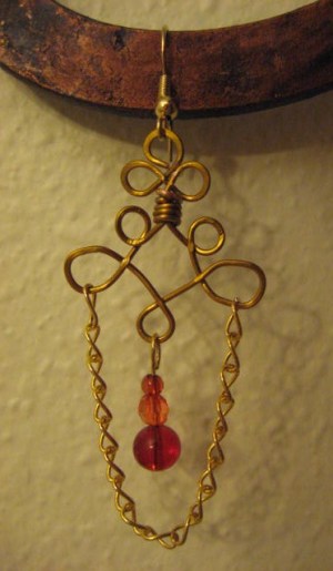 Brass tone wire and chain link earring with red beads.