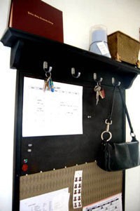 Black message board with shelf above.