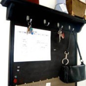 Black message board with shelf above.
