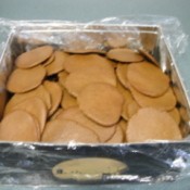 Baked cookies in a box covered with Saran Wrap.