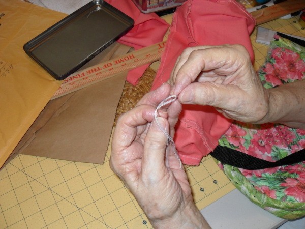 Sewing on Buttons for Crafts, threading needle with white thread.