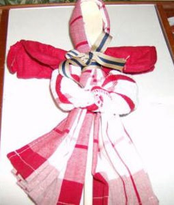 Red and white dish towel folded to resemble an angel.