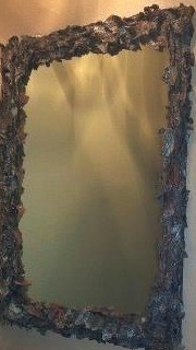 Framed mirror covered with pieces of tree bark.
