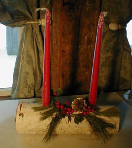 Birch log with two red candles in drilled holes.