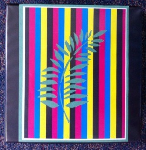 Front of binder with a striped paper insert, with decorative leaf motif in center.