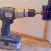 Toilet brush mounted on cordless drill.