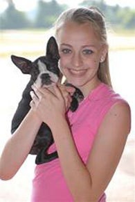 Smiling teenage girl holding her black and white small dog