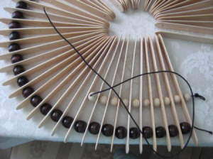 Closeup of threading smaller beads.