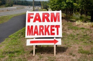 A sign pointing to a farmers market.