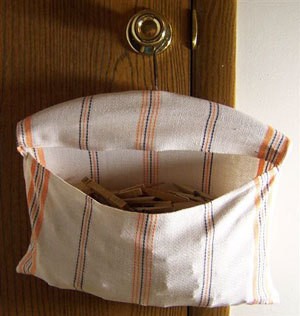 Tea towel on wooden hanger clothespin bag.