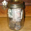 Money Jar full of coins and a $20 bill.