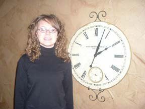 Teen girl next to clock.